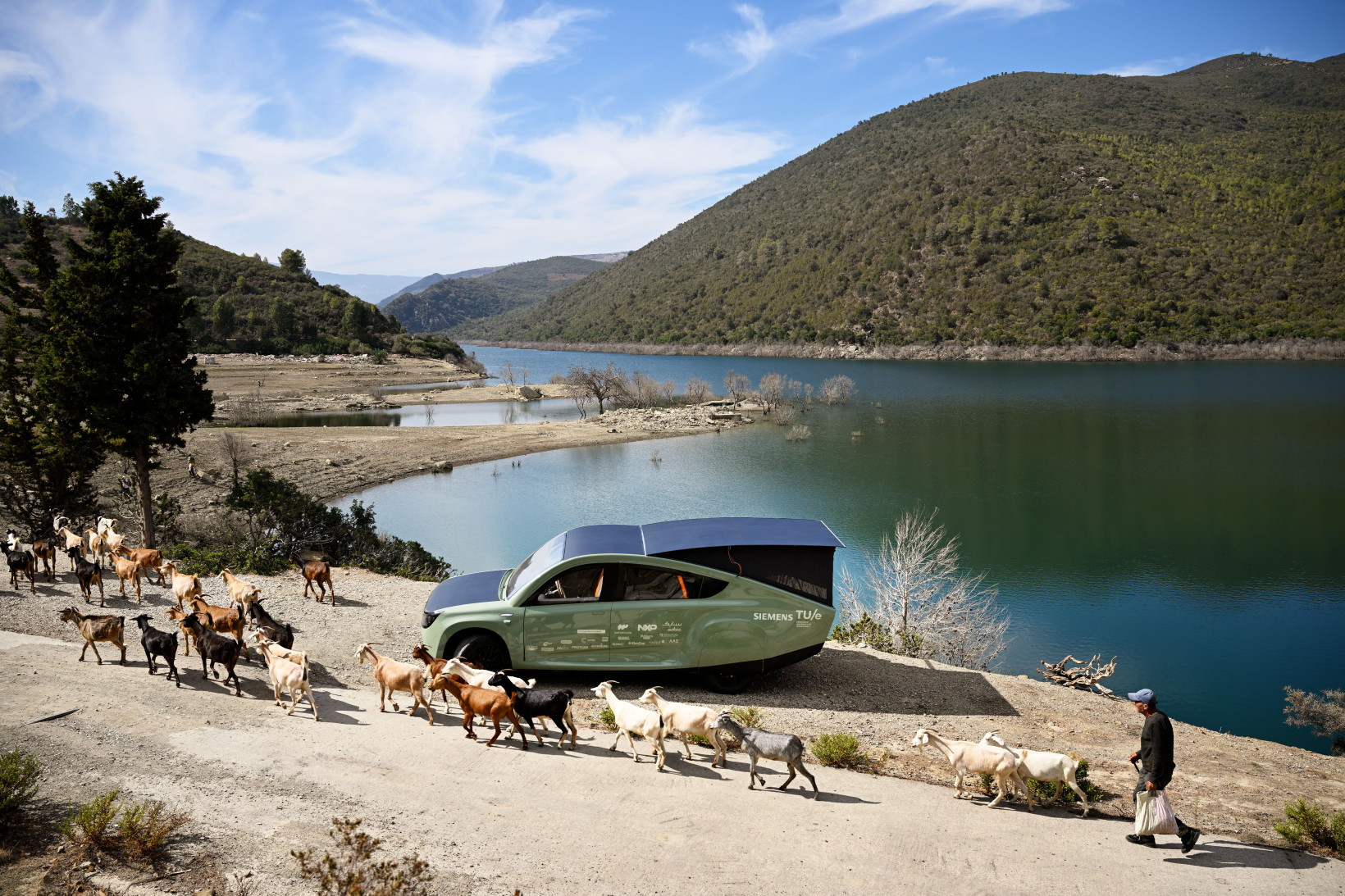 a solar car parked next to a lake in morocco