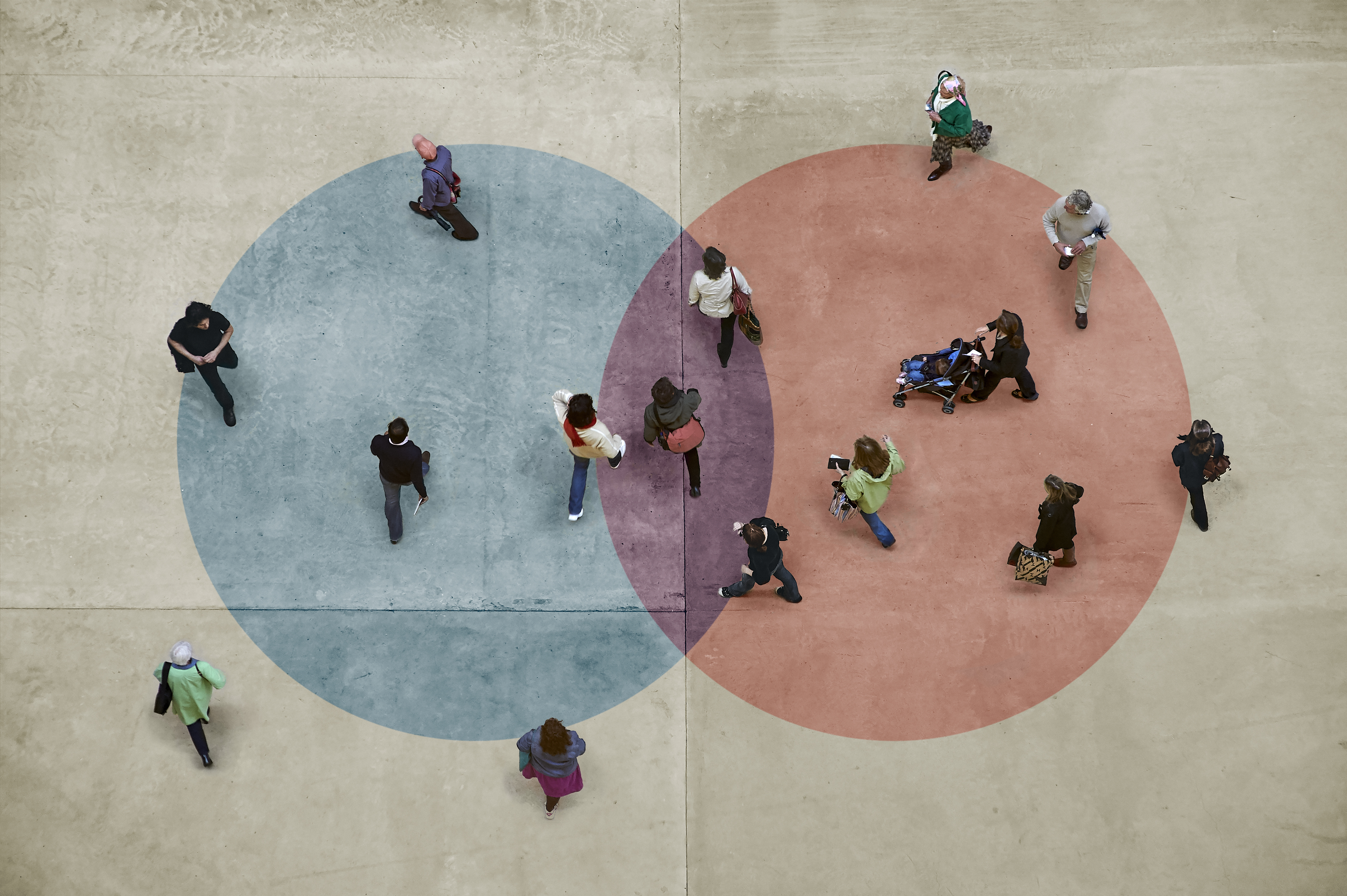 Image of overlapping blue and red circles with people standing in and around both.